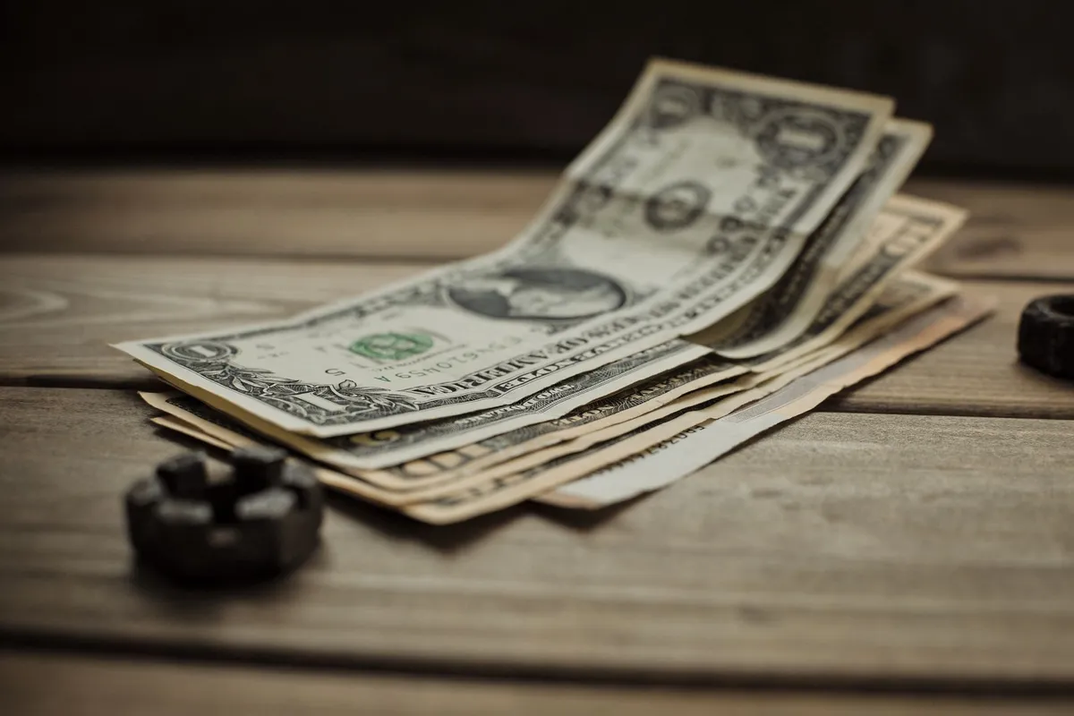 Close-up of US dollar bills on a wooden table, highlighting the value of vintage currency in finance.